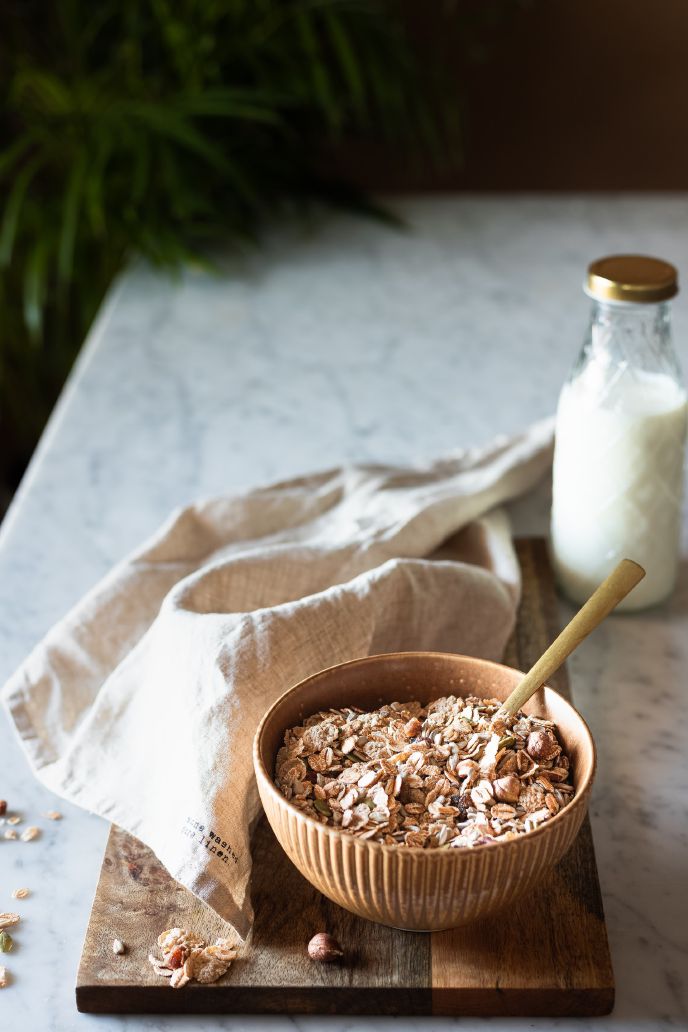 Bowl of oats with a spoon on a chopping board