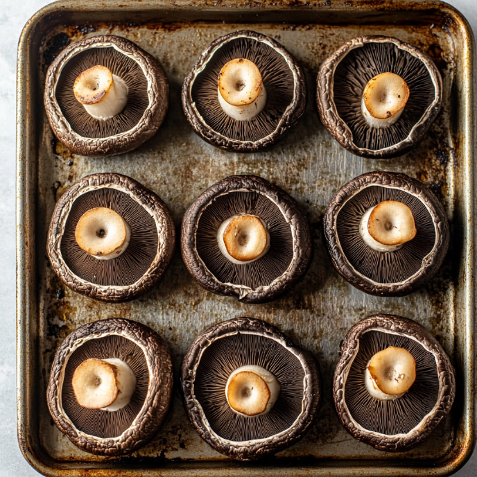 Portobello mushrooms arranged on a baking tray, top view