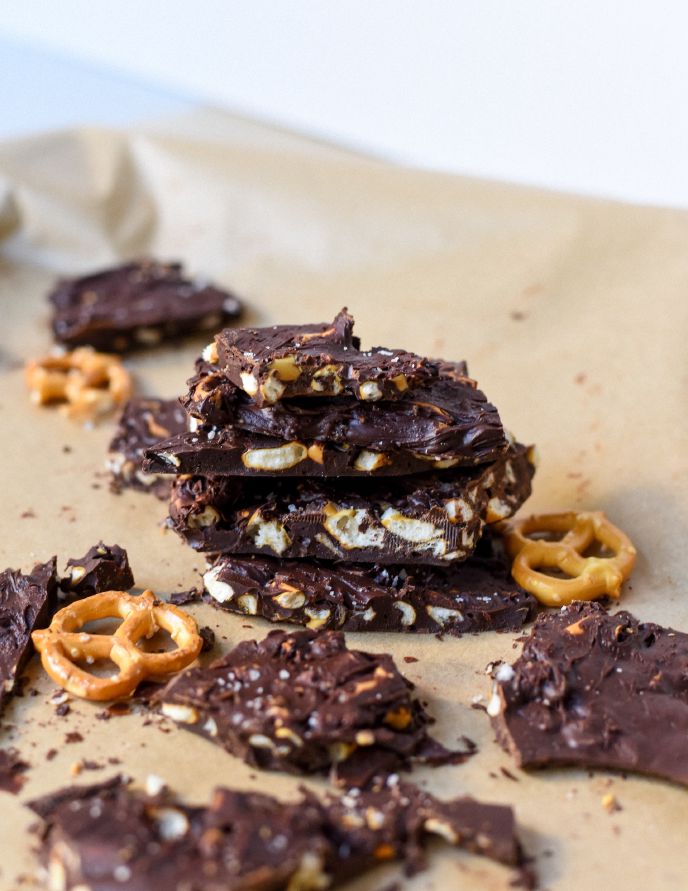 Pieces of brownie brittle on a table with pretzles